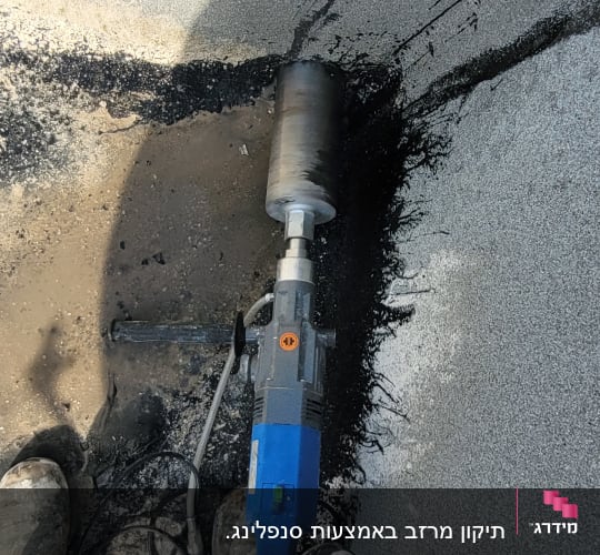 מקדחה חשמלית כחולה על משטח בטון רטוב